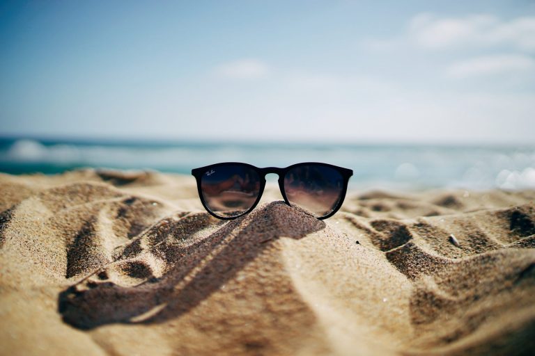 Uitgelichte afbeelding voor de blog voorbereid de zomer in. Een zonnebril die op het strand ligt. Deze afbeelding is puur decoratief.